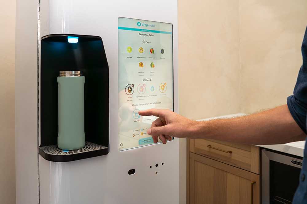 A close-up of a man's hands using a beautiful, modern DropWater water cooler from Avcoa Vending in Chicago, IL.