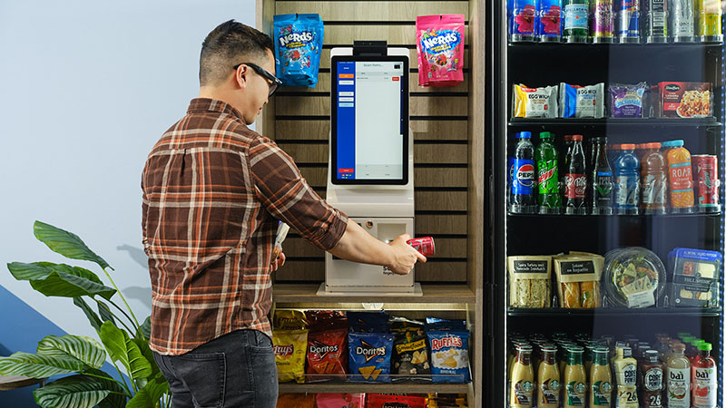 A man pays for his refreshing drink at a micro market kiosk from Avcoa Vending, Chicago, IL.