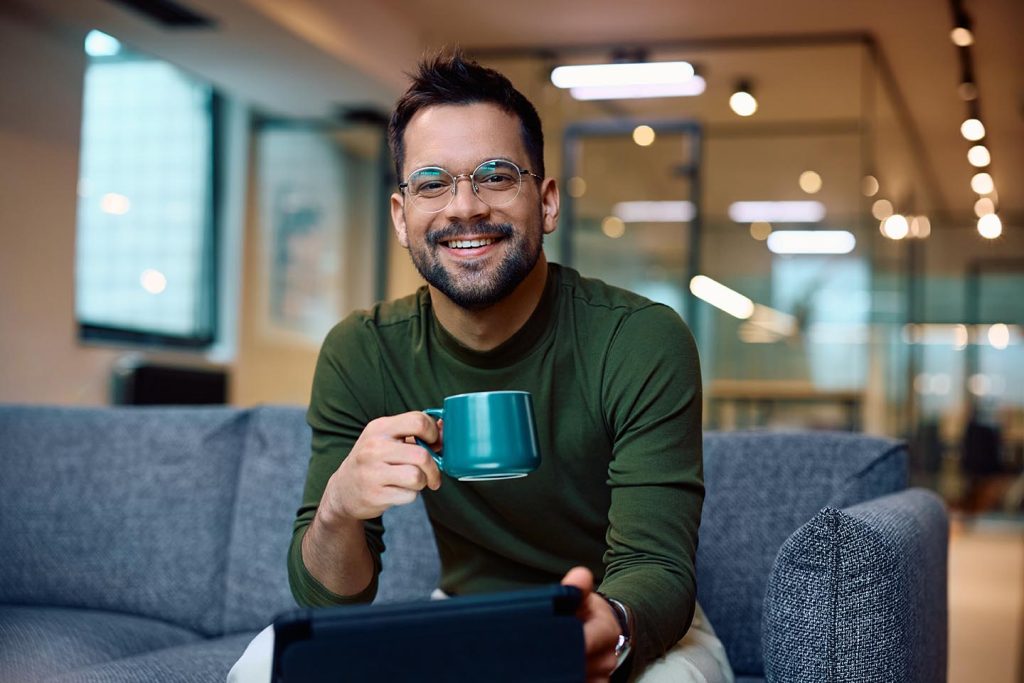 A man enjoying a delicious cup of coffee in a break area of his office. Office Coffee Service​ from Avcoa Vending, Chicago, IL.