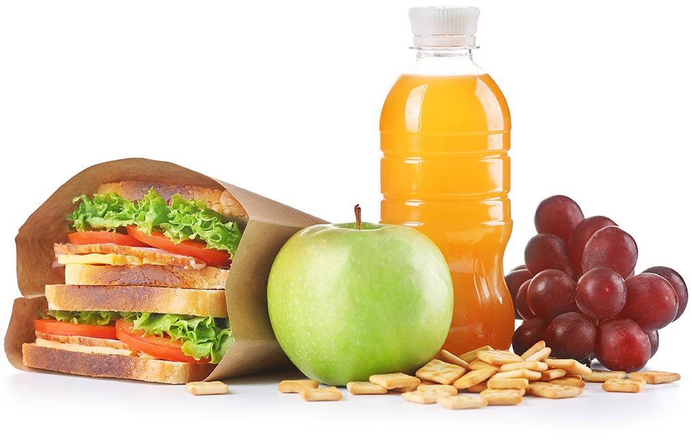 A sandwich, apple, grapes, and small crackers on a white surface. Office Vending Services​ from Avcoa Vending, Chicago, IL.