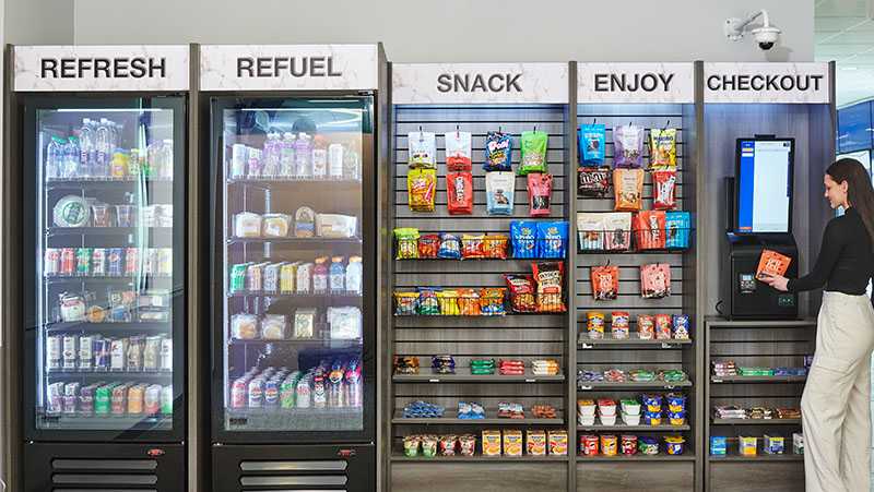 A woman paying for her items at a modern micro market provided by Avcoa Vending in Chicago, IL.